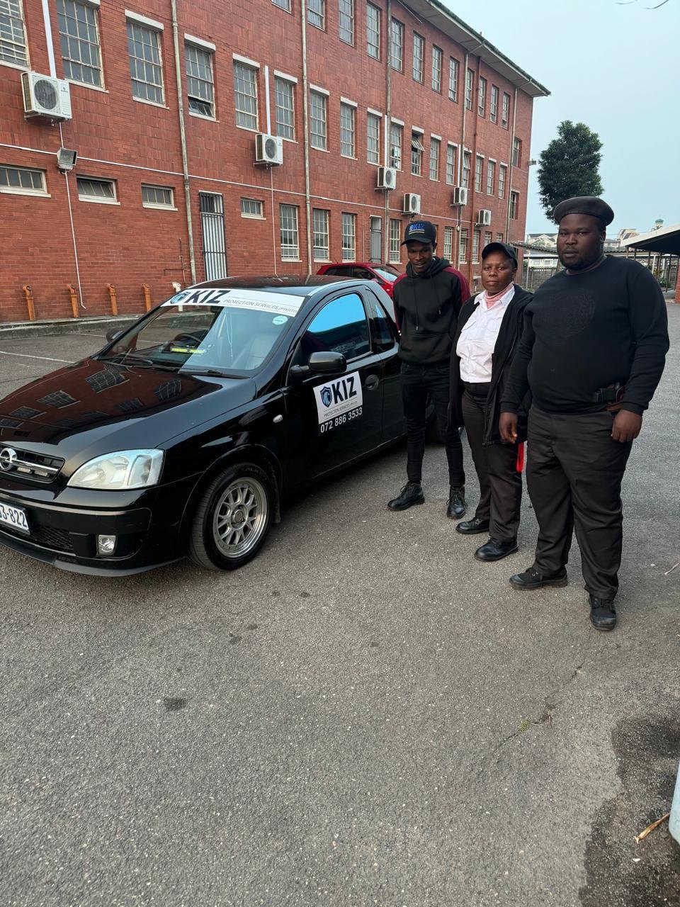 KIZ Protection Services staff with a branded vehicle